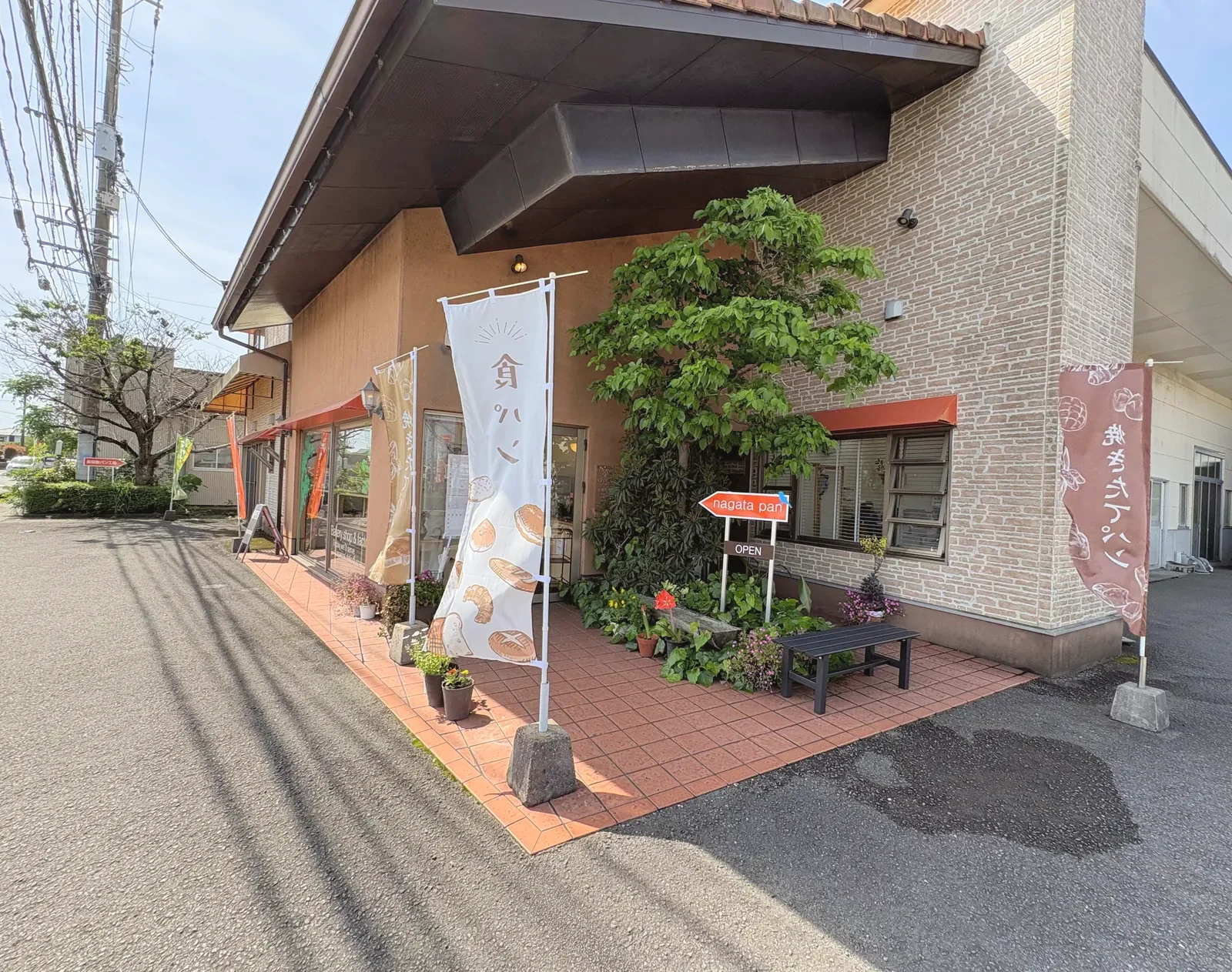 本社直売所の外観。入口の前にのぼりと看板が立つ