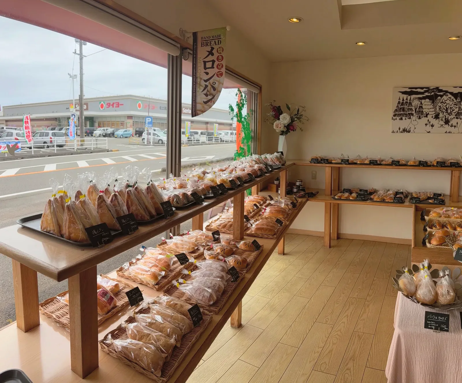 本社直売所の店内。窓ぎわの台に袋入りのパンが並ぶ